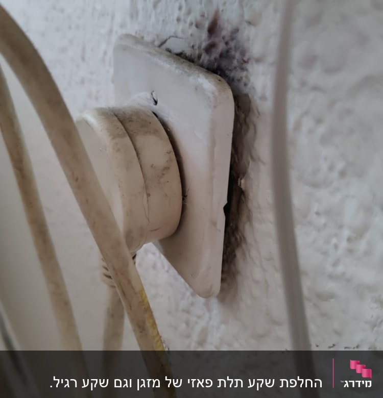 שקע חשמלי עם סימני שריפה וכבלים מחוברים